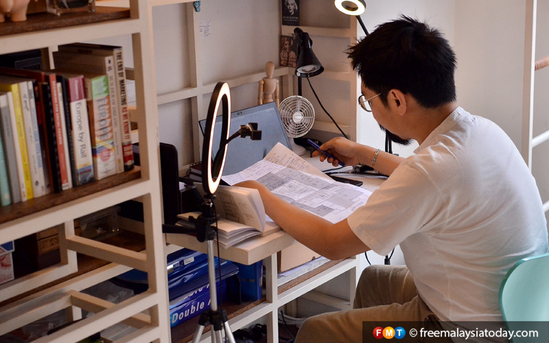 A man leans over a desk reading a document, in a domestic setting - to illustrate the idea of working from home.