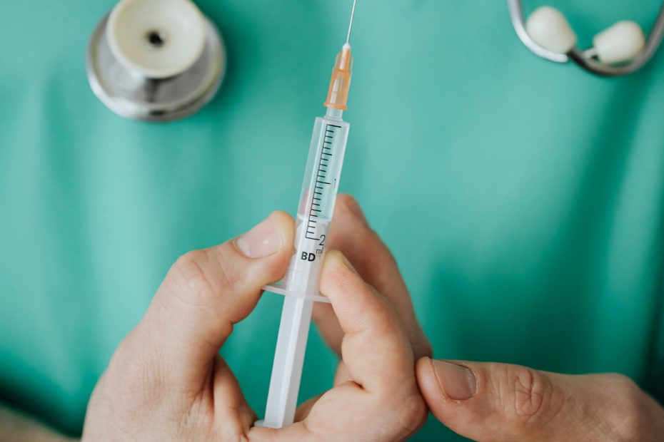 A medical professional holding a needle ready to inject. For illustrative purposes only.
