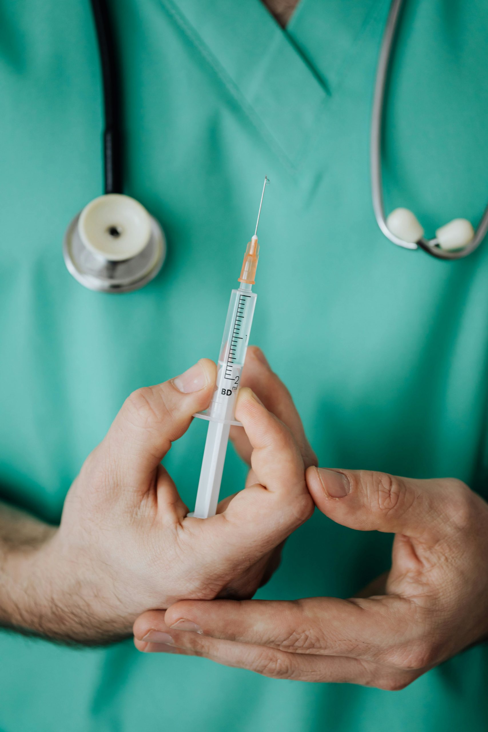 A medical professional holding a needle ready to inject. For illustrative purposes only.